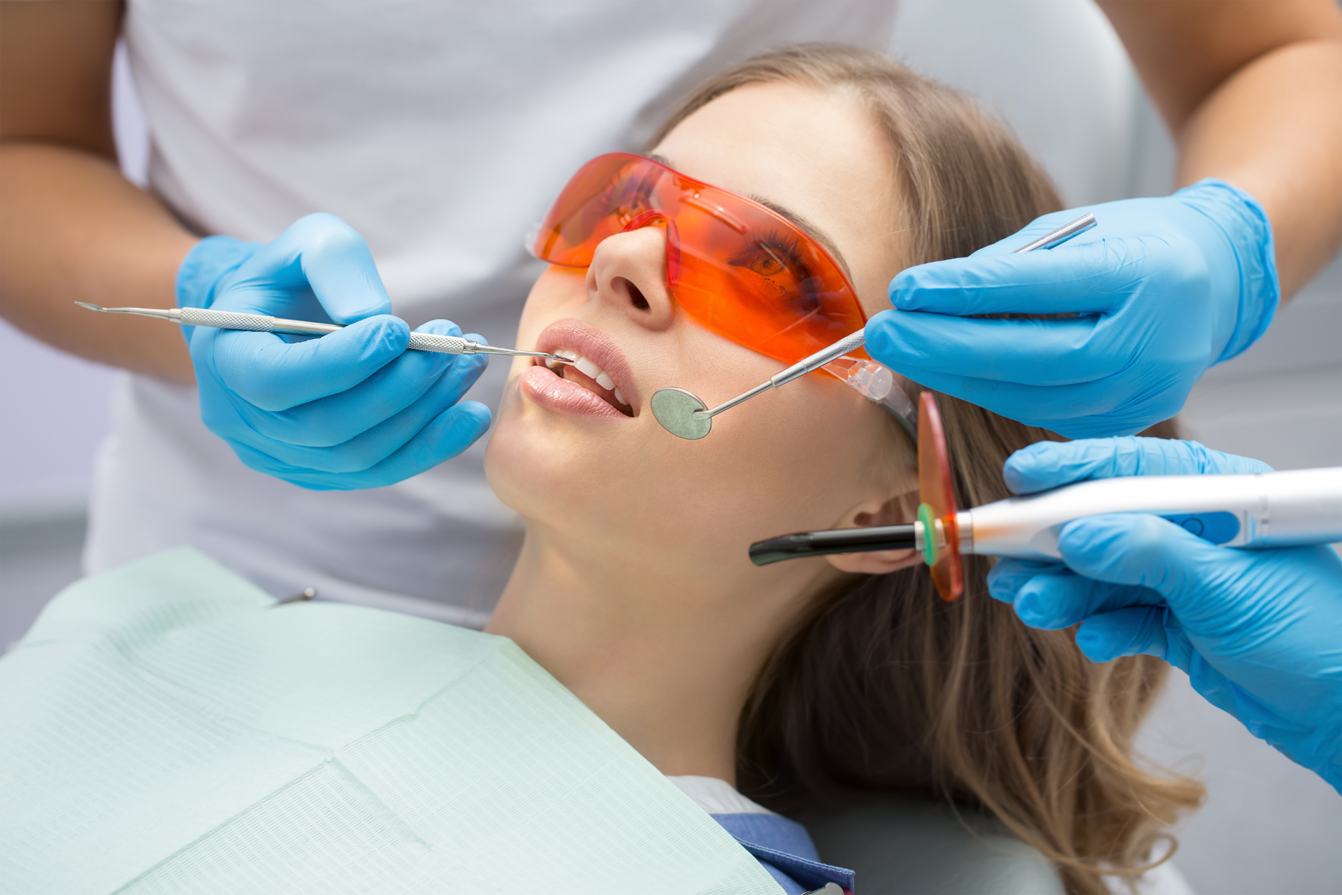 dentists insert inlay in woman's teeth